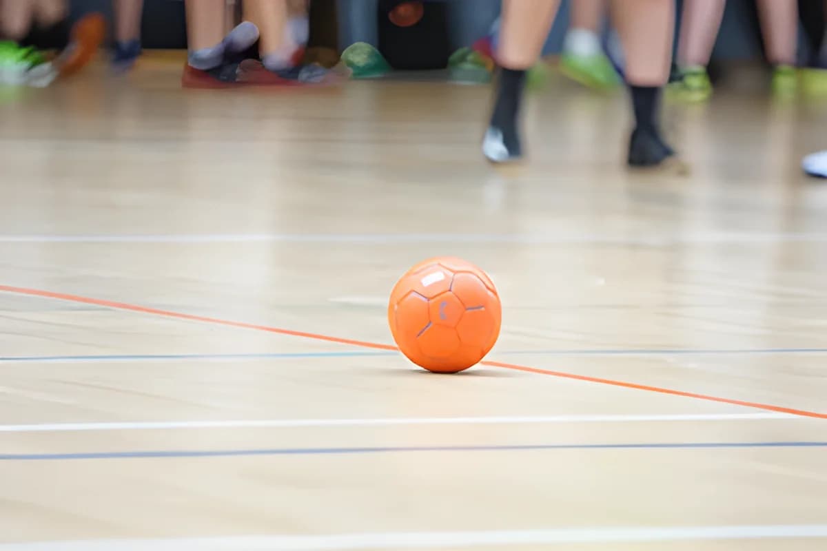 Orange handball on indoor court
