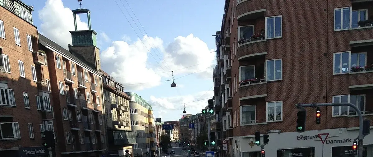 Urban street with brick buildings and traffic lights in Aalborg, Denmark.