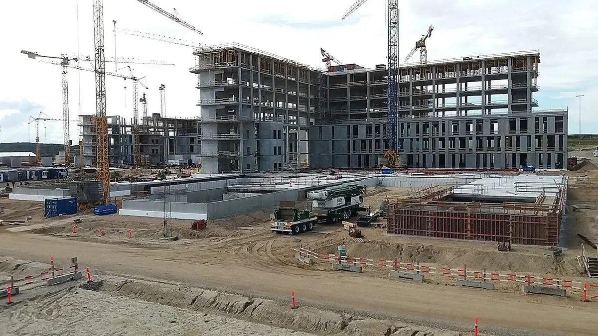 Large hospital construction site with cranes and partially built buildings.