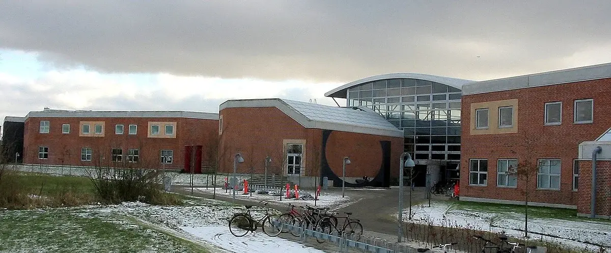 Aalborg University campus buildings with bicycles and snow on the ground.