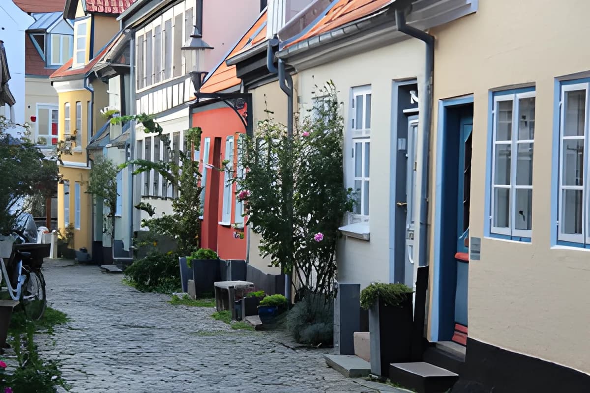 Narrow cobblestone street lined with colorful historic houses in Aalborg
