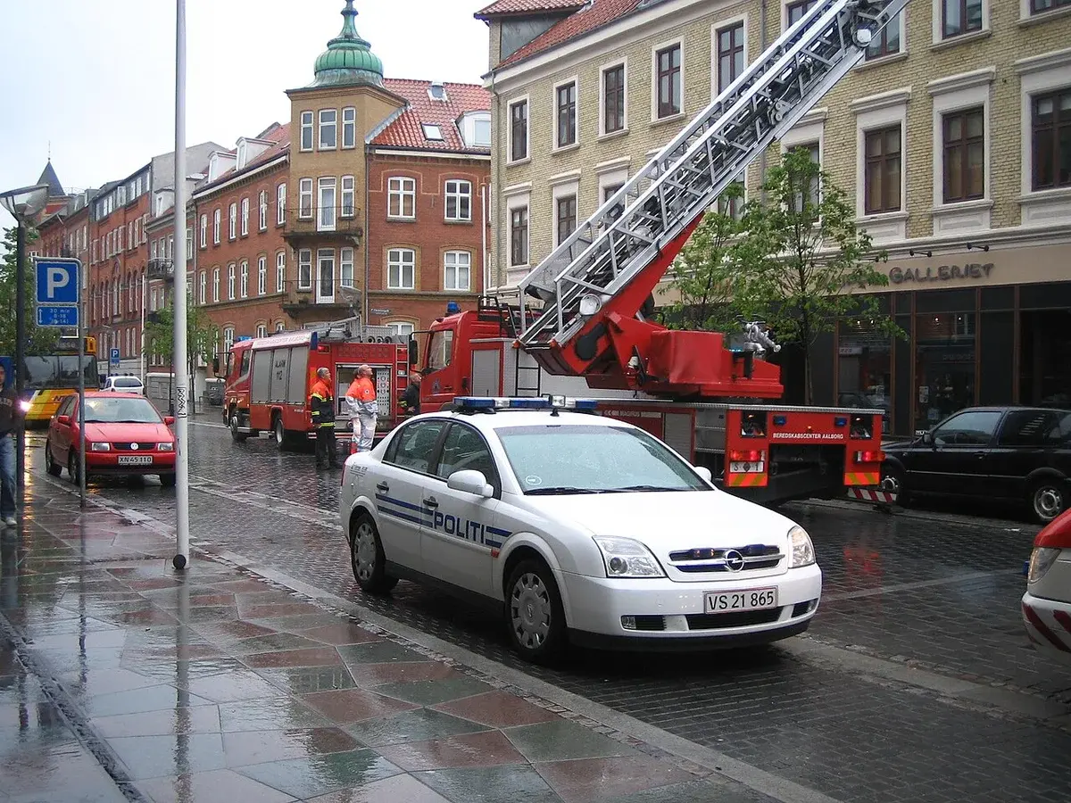 Police car and fire truck on a rainy street in Aalborg, Denmark.