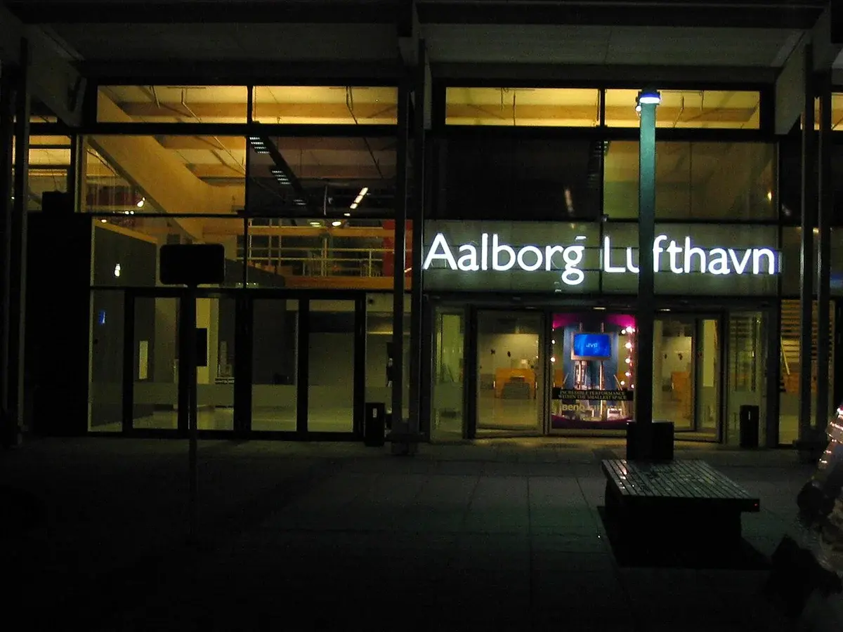 Illuminated entrance to Aalborg Airport at night.