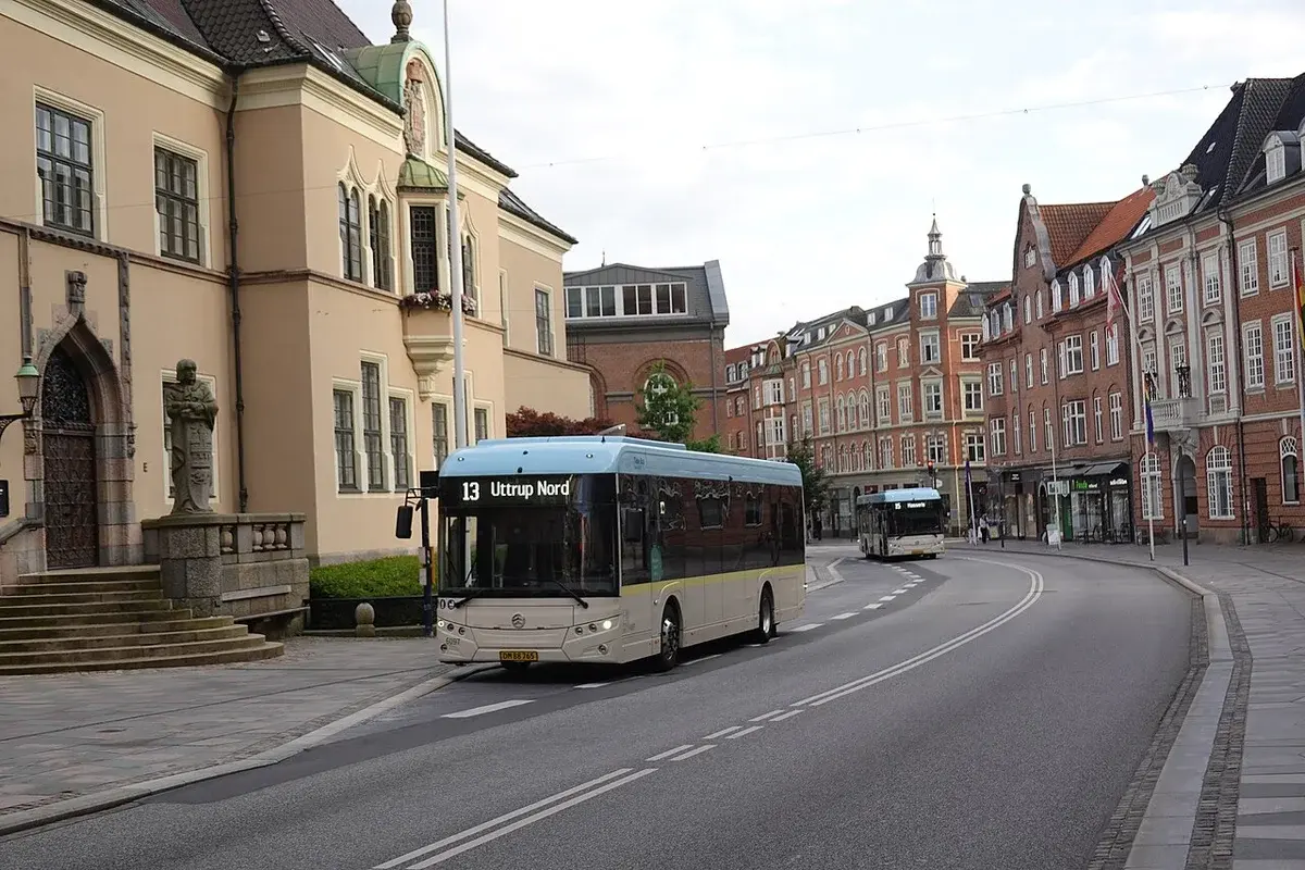A public bus driving through a street in Aalborg, Denmark.