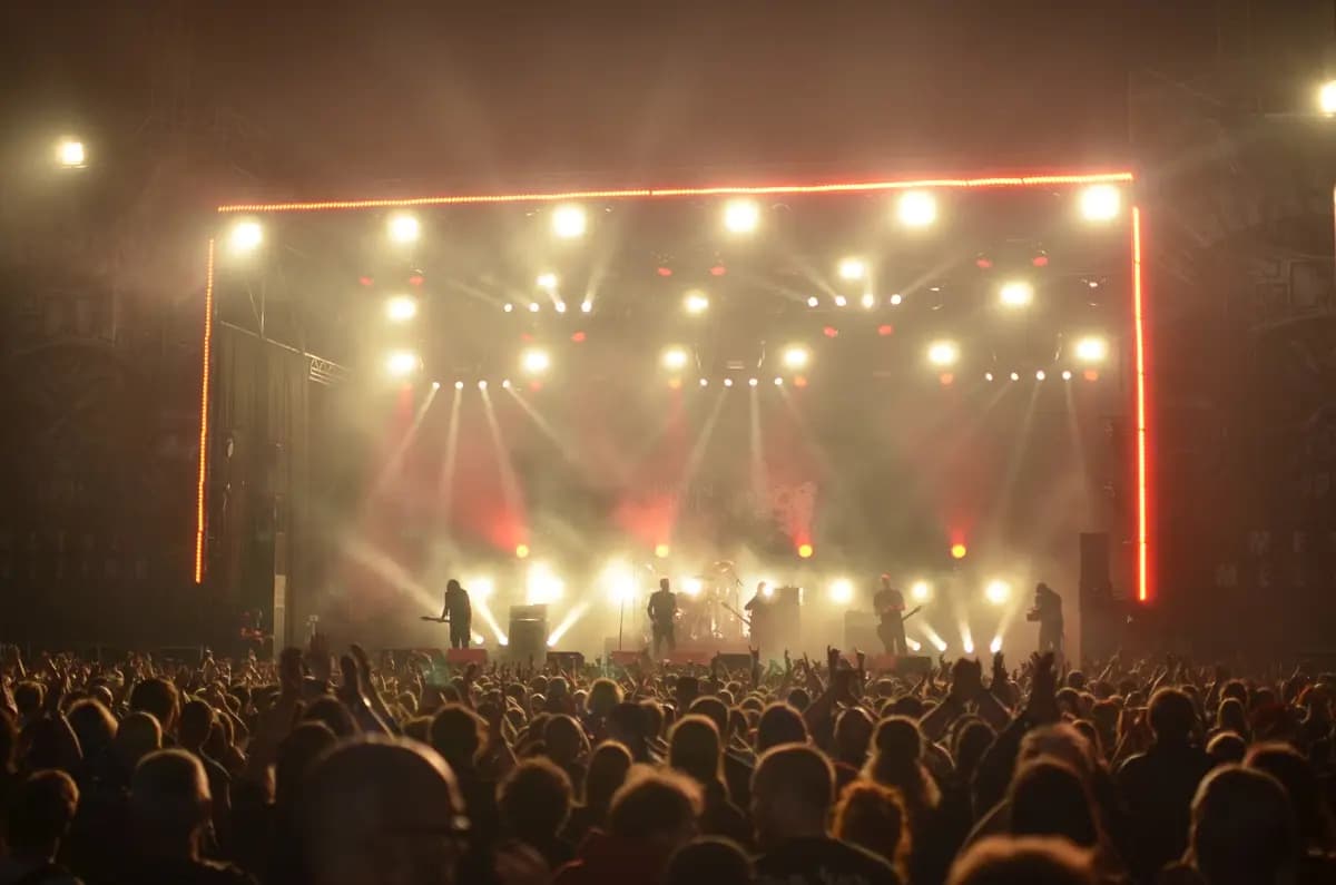 Band performing live on a brightly lit stage with audience