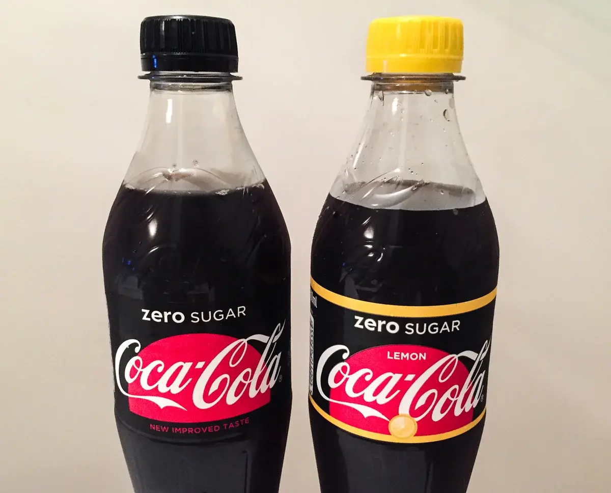 Two bottles of Coca-Cola Zero Sugar, including a lemon variant, side by side.