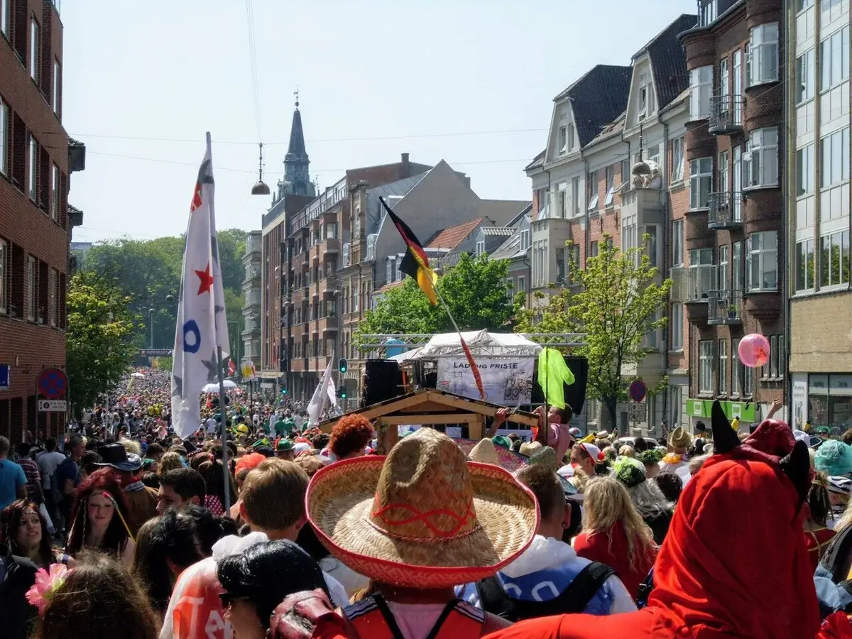 Crowded carnival parade on a city street in Aalborg, Denmark.